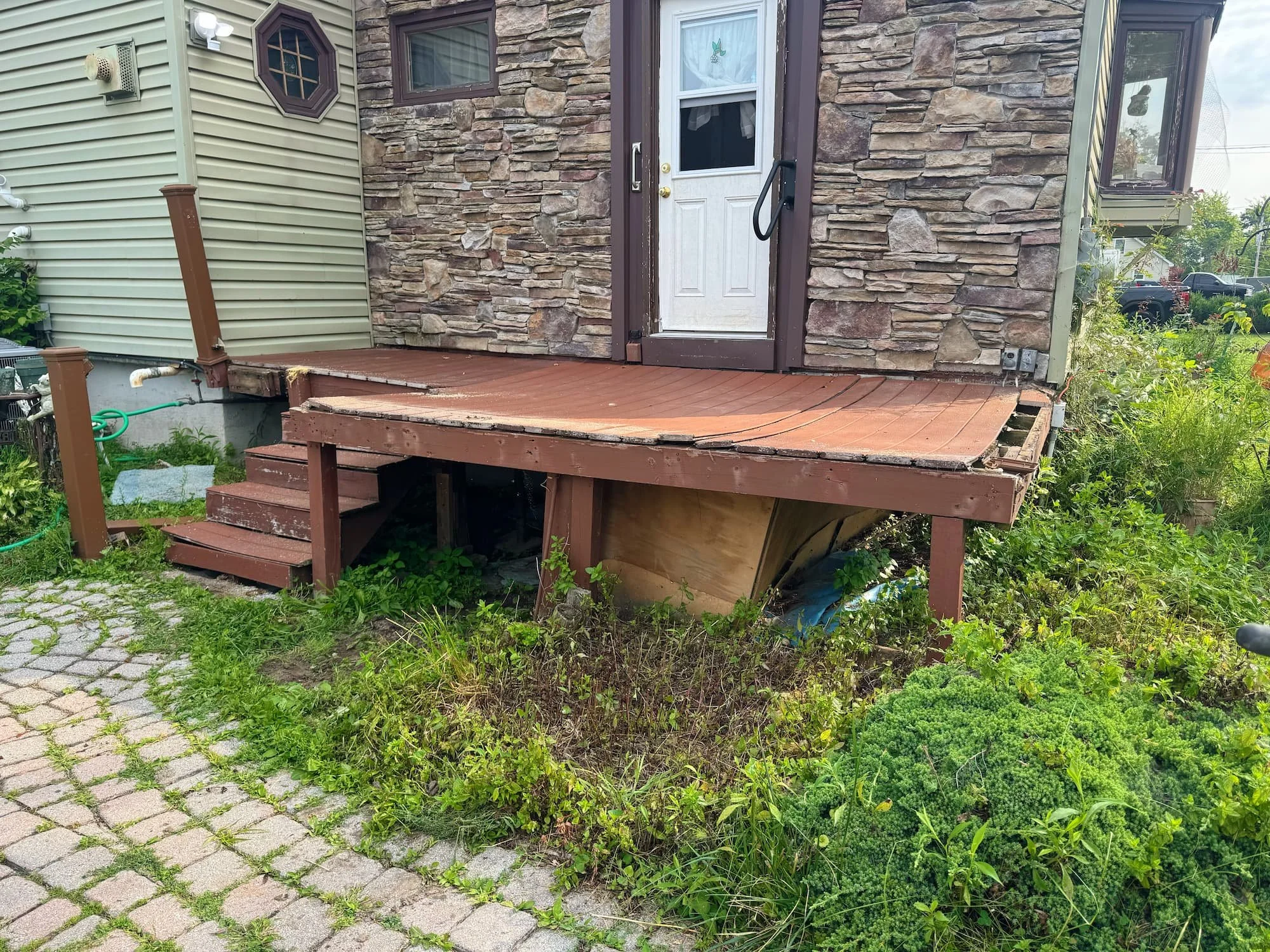 Damaged wood deck before replacement showing deteriorated boards and exposed framing at a Central New York home