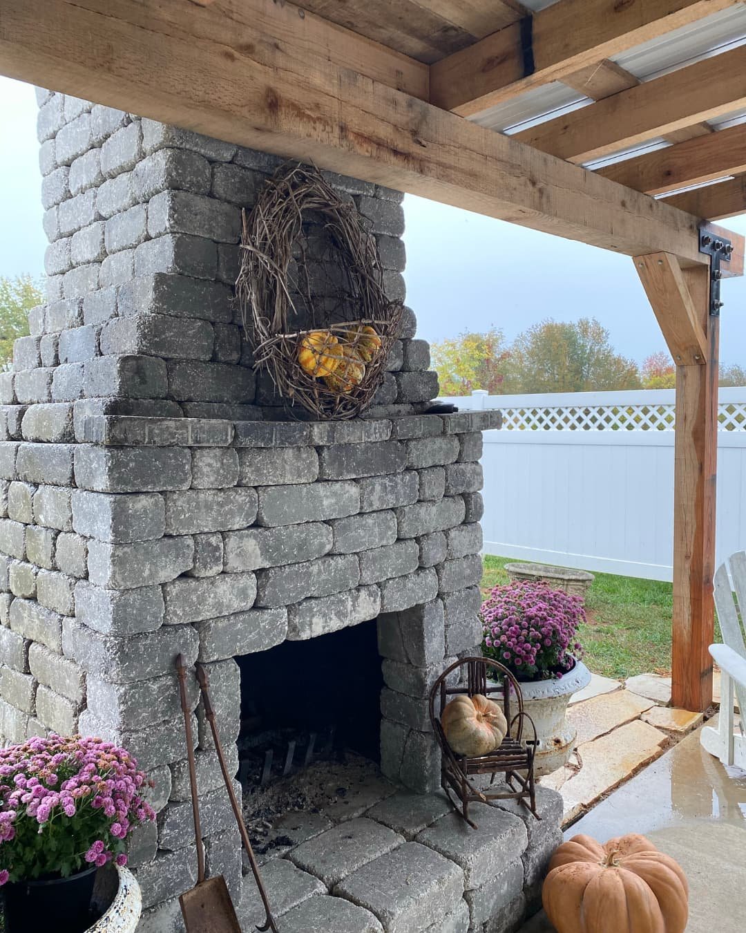 Outdoor fireplace inspiration showing a stone fireplace in a spacious enclosed outdoor living room.