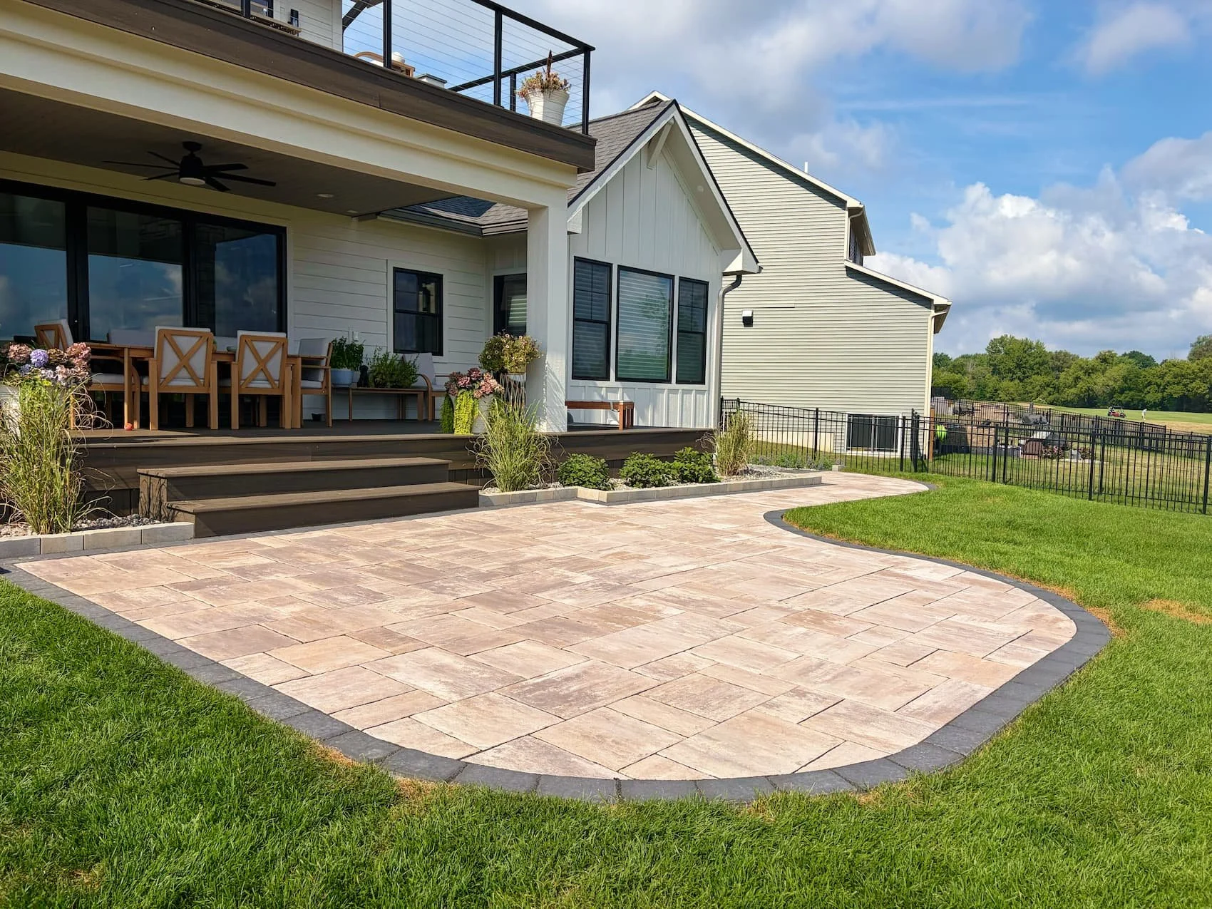 Paver patio with curved border and surrounding lawn at a Central New York home