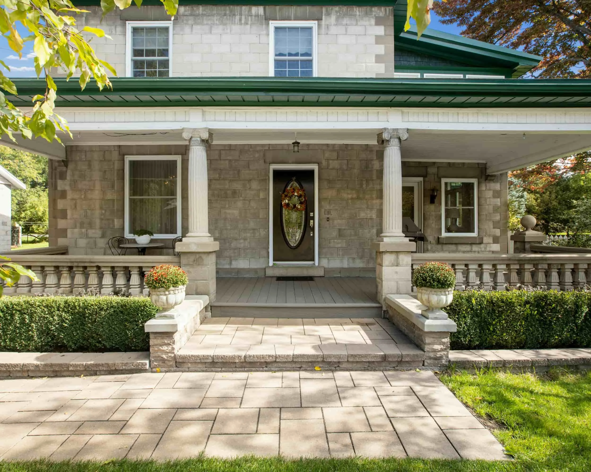 Custom paver walkway and stone patio entrance with structured foundation landscaping