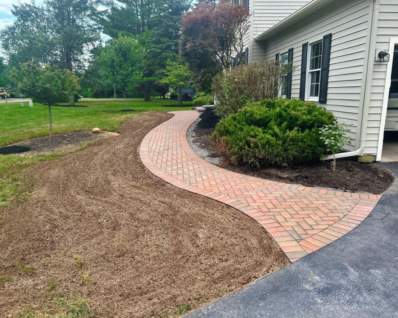 Front yard walkway and planting bed completed by Pines and Pavers in Manlius, New York.
