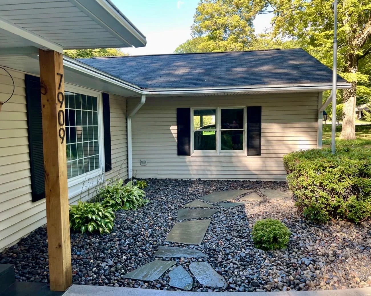 Front shrub bed landscaping at a Central New York home with decorative rock, fresh mulch, and neat planting layout.