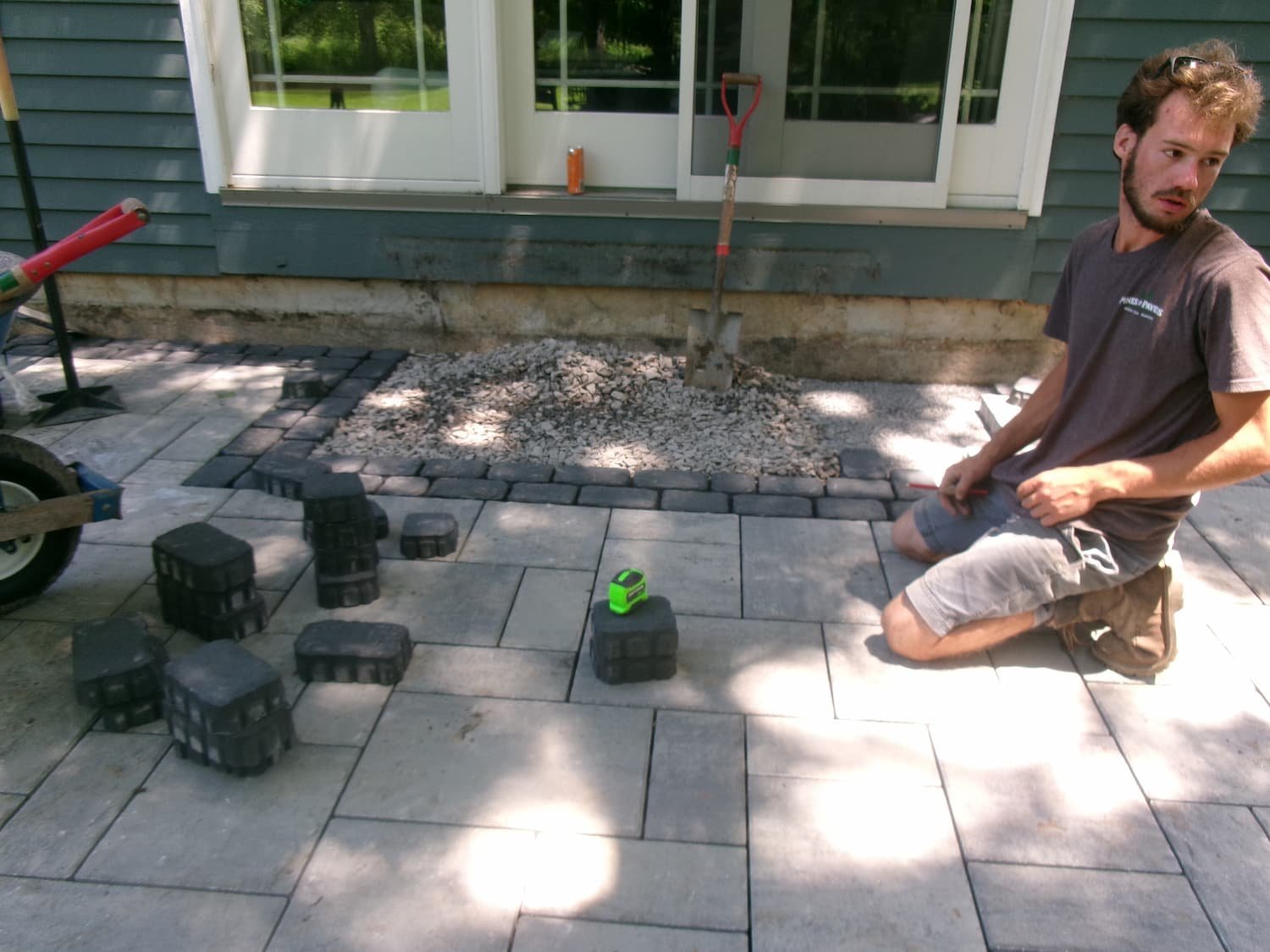 Professional installation of custom patio pavers during a residential hardscape project in Central New York.