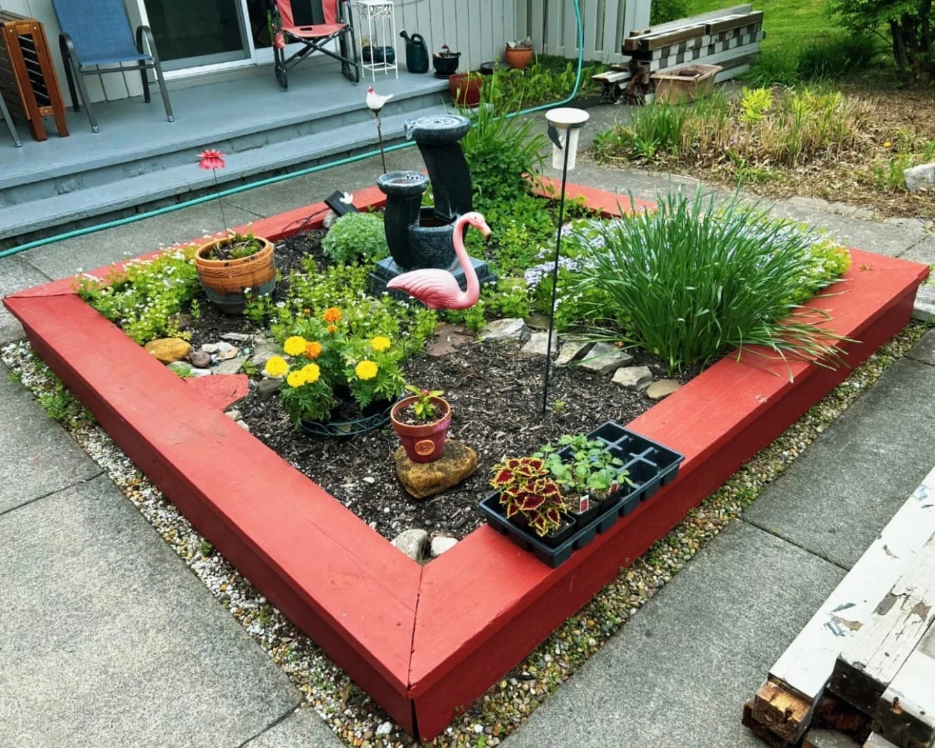 Custom raised garden bed at a Central New York home with planted flowers and a clean finished border.