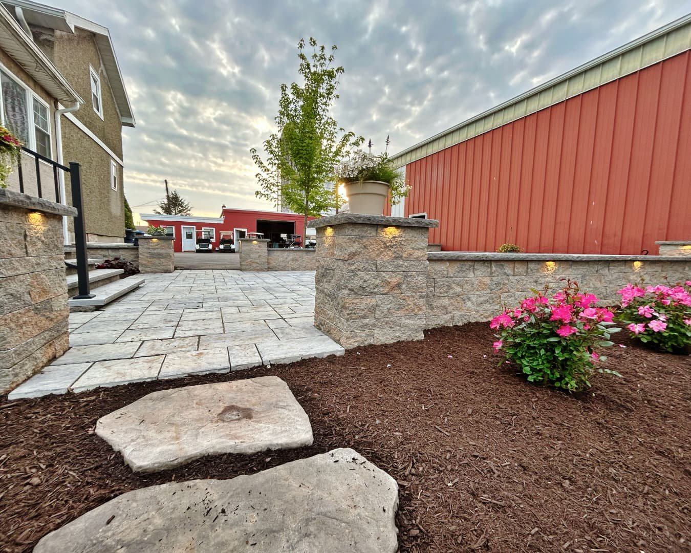Foundation landscape bed with flowering plants completed by Pines and Pavers in Fayetteville, New York.