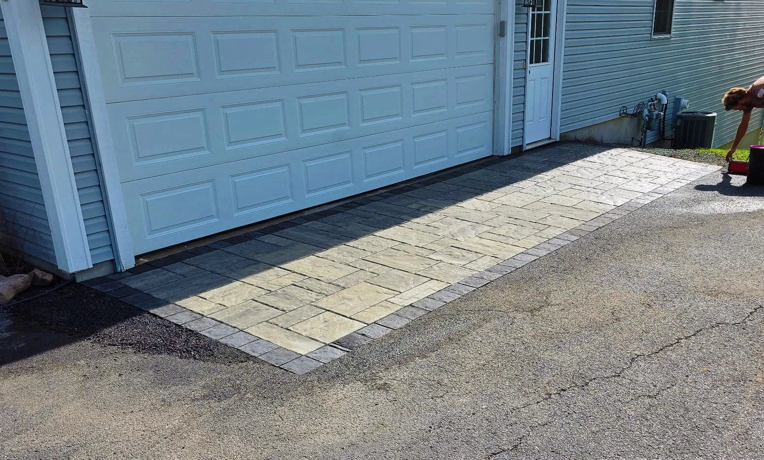Completed concrete driveway repair beside a residential garage in Central New York.