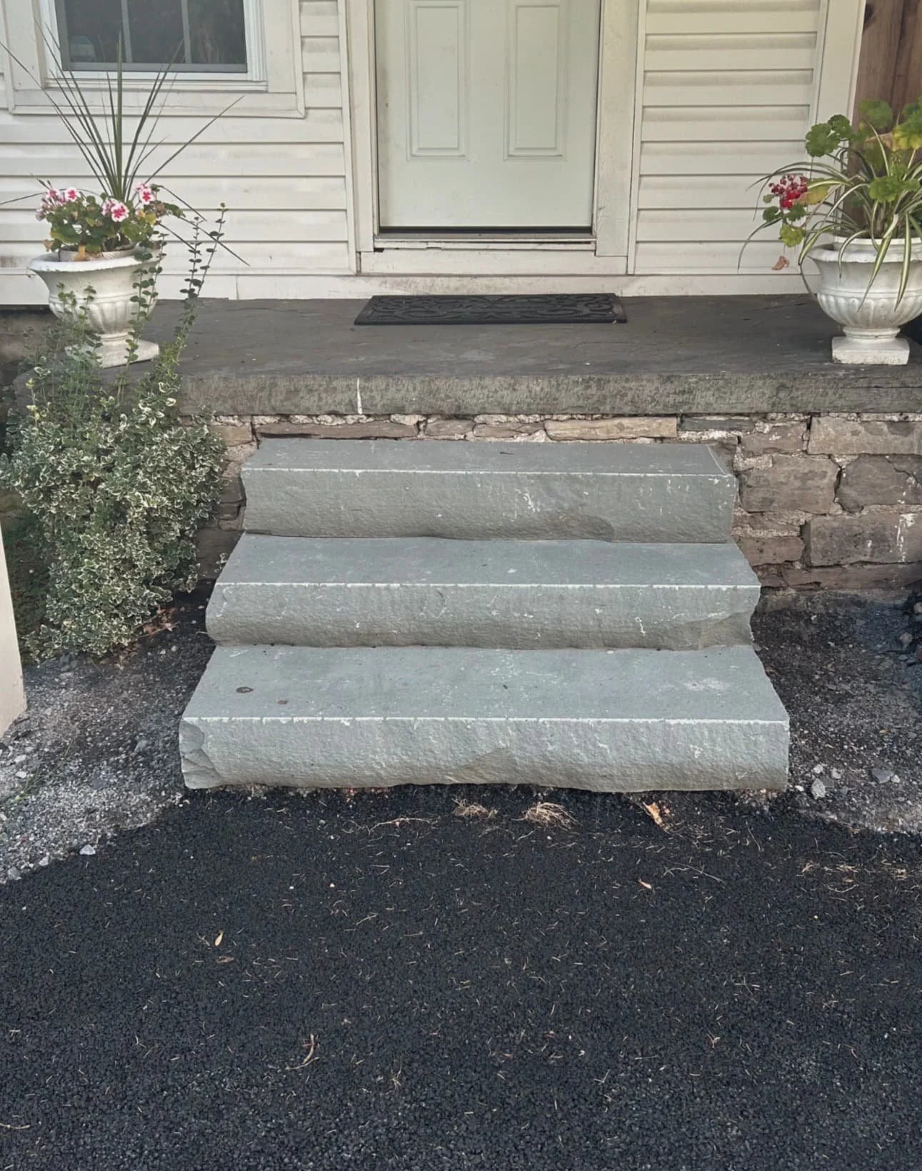 Front step and walkway view at a Central New York home with lawn transition and entry hardscape detail.