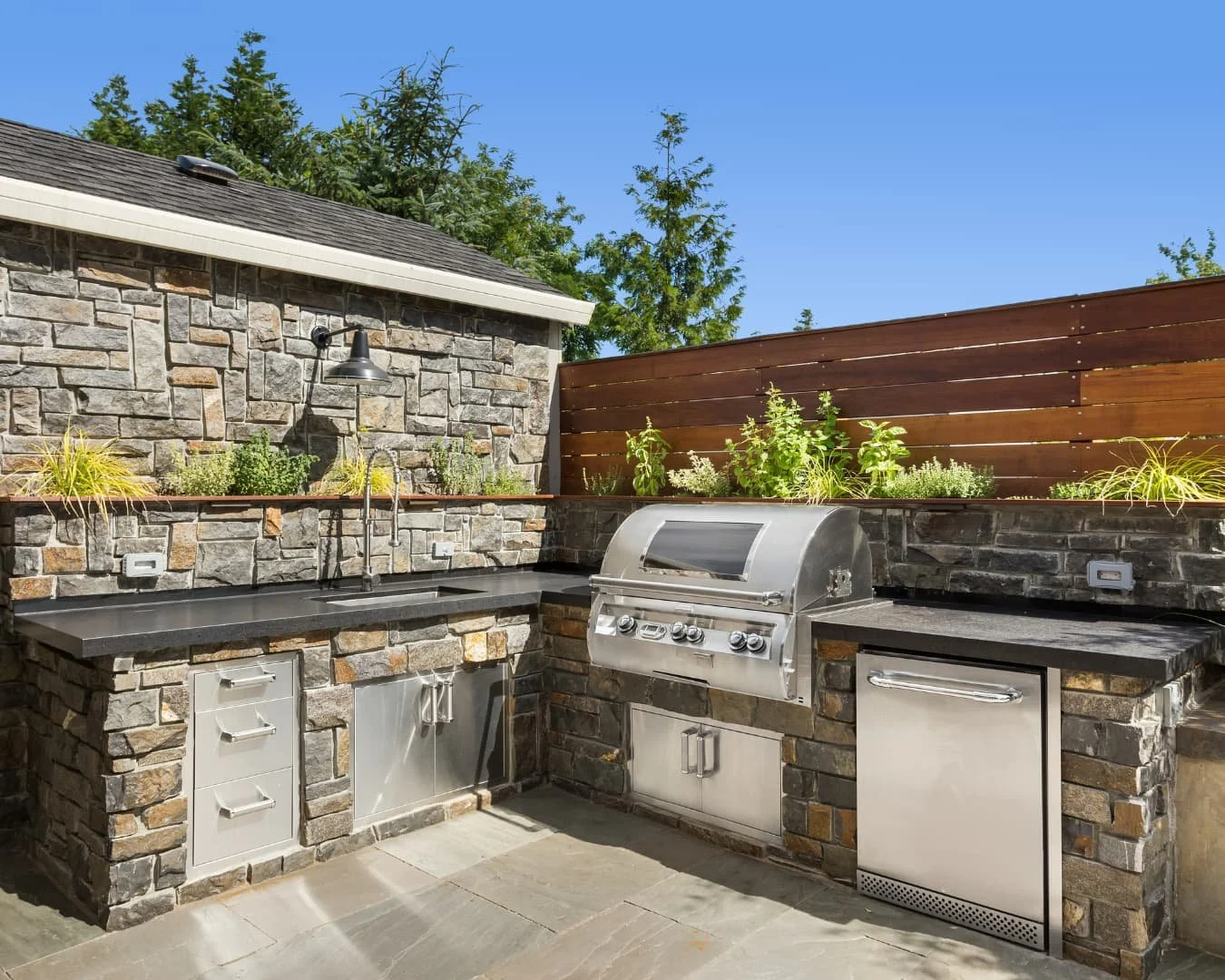 Outdoor kitchen inspiration showing a covered island grill setup with seating and prep space.
