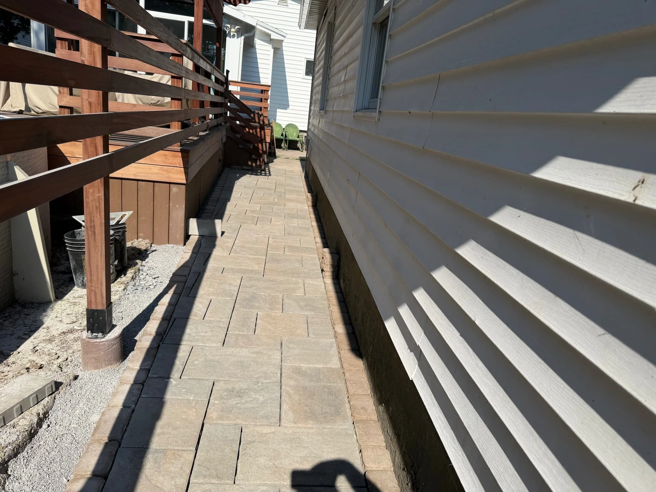 New shrubs installed in a freshly prepared landscape bed beside a backyard deck in Central New York.