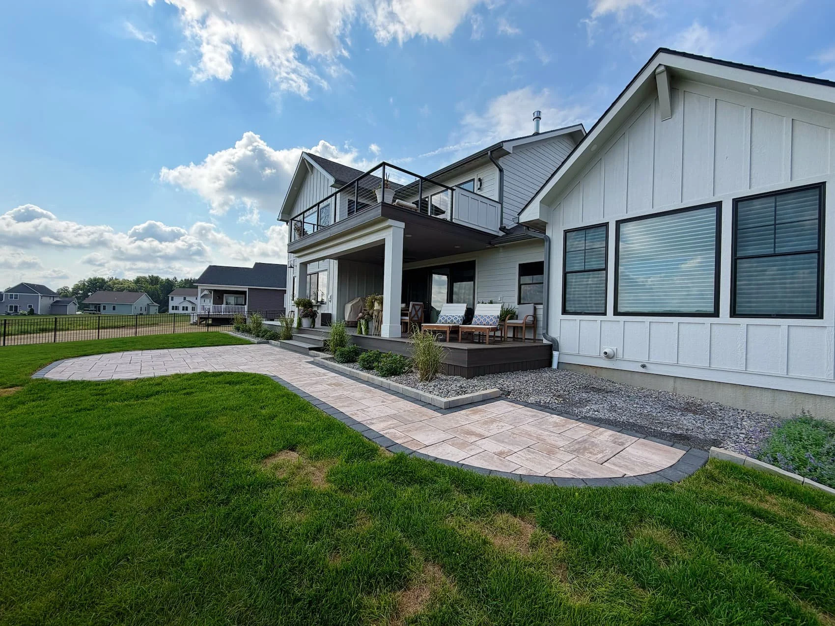 Custom paver patio extending from a covered backyard living space in Central NY