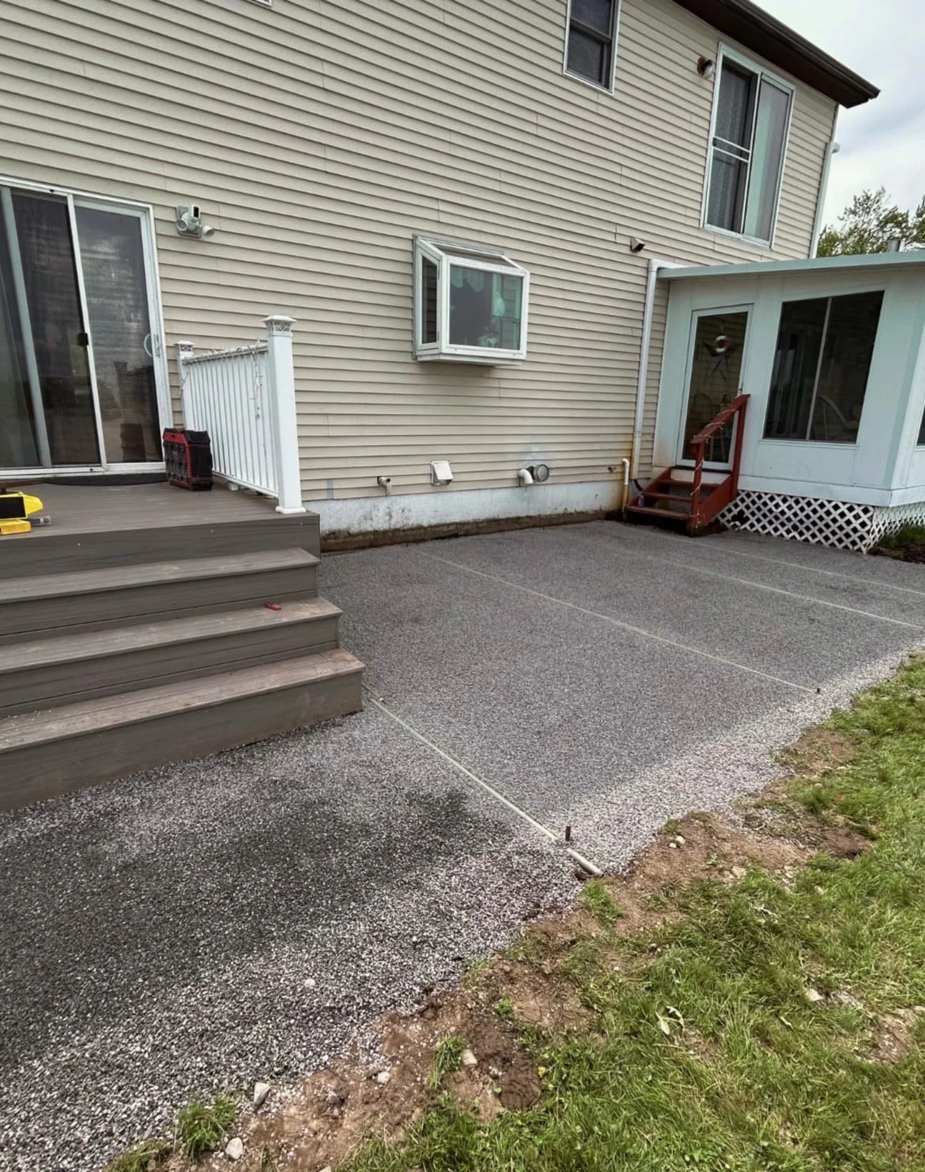 Waterfront paver patio at an Upstate New York home with spacious hardscape layout and open views.