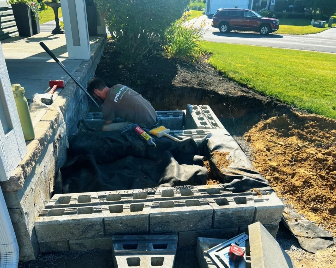 Front entry step installation at a Manlius, NY home with curved paver detailing and finished lawn edging.