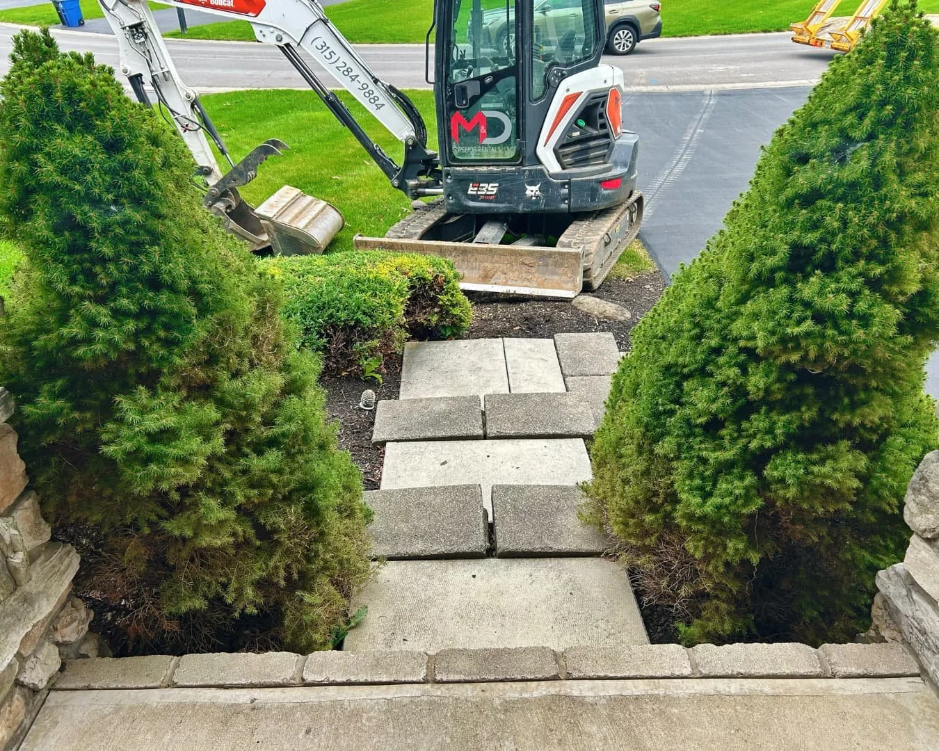 Natural stone steps between evergreens completed by Pines and Pavers in Skaneateles Falls, New York.