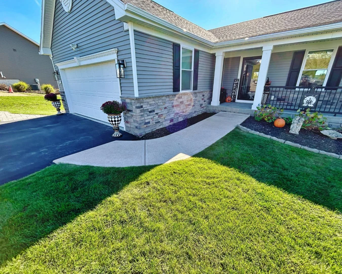     Front entry path with paver walkway detail beside a stone veneer home exterior.