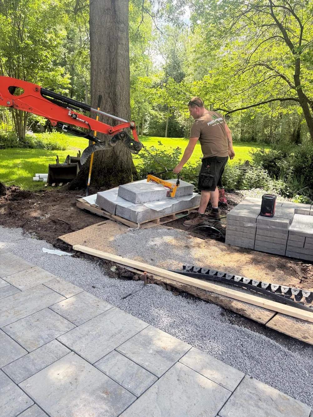 Pines and Pavers team member installing and aligning pavers during a custom hardscape project in Central New York.