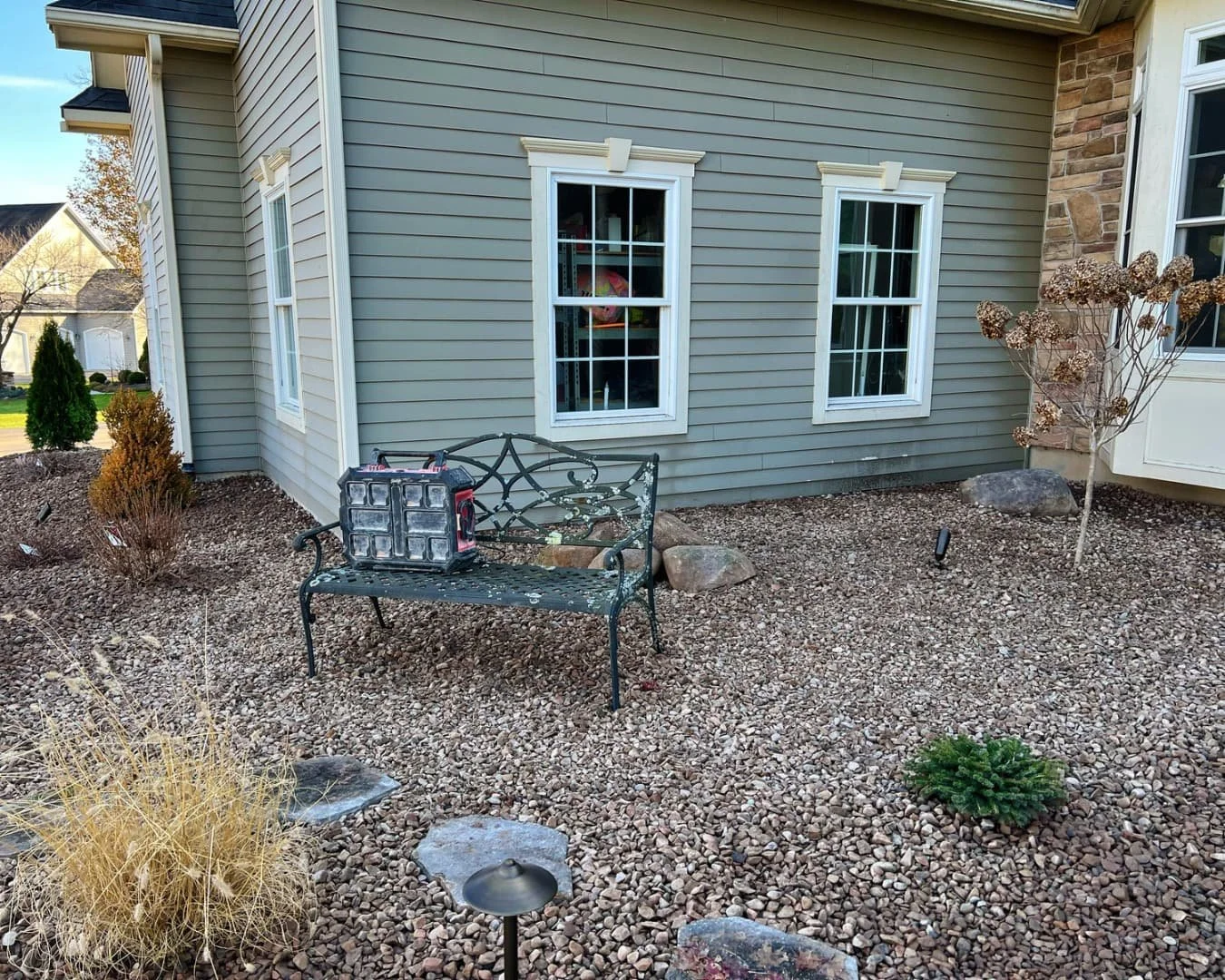 Rock bed landscape by the home exterior completed by Pines and Pavers in Fayetteville, New York.