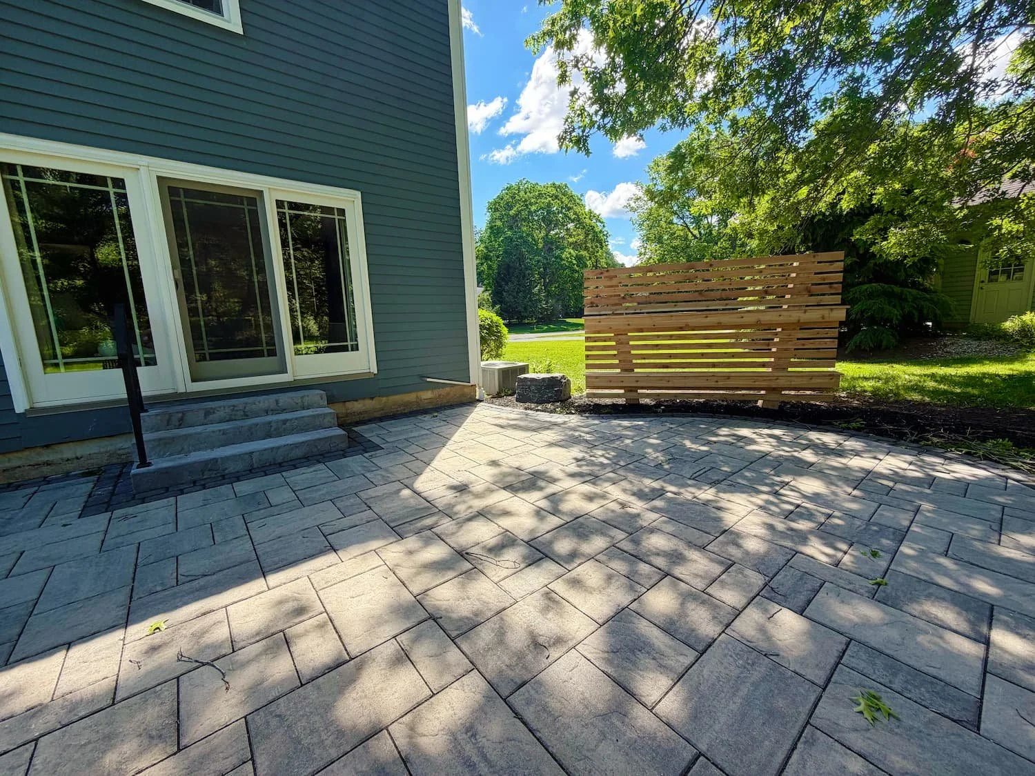 Finished backyard hardscape featuring a custom paver patio designed for outdoor living in Central New York.