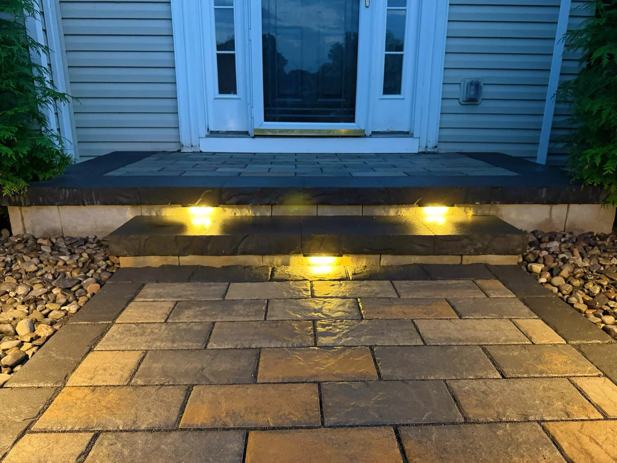 Decorative stone landscaping with established shrubs and greenery at a Central NY residence.