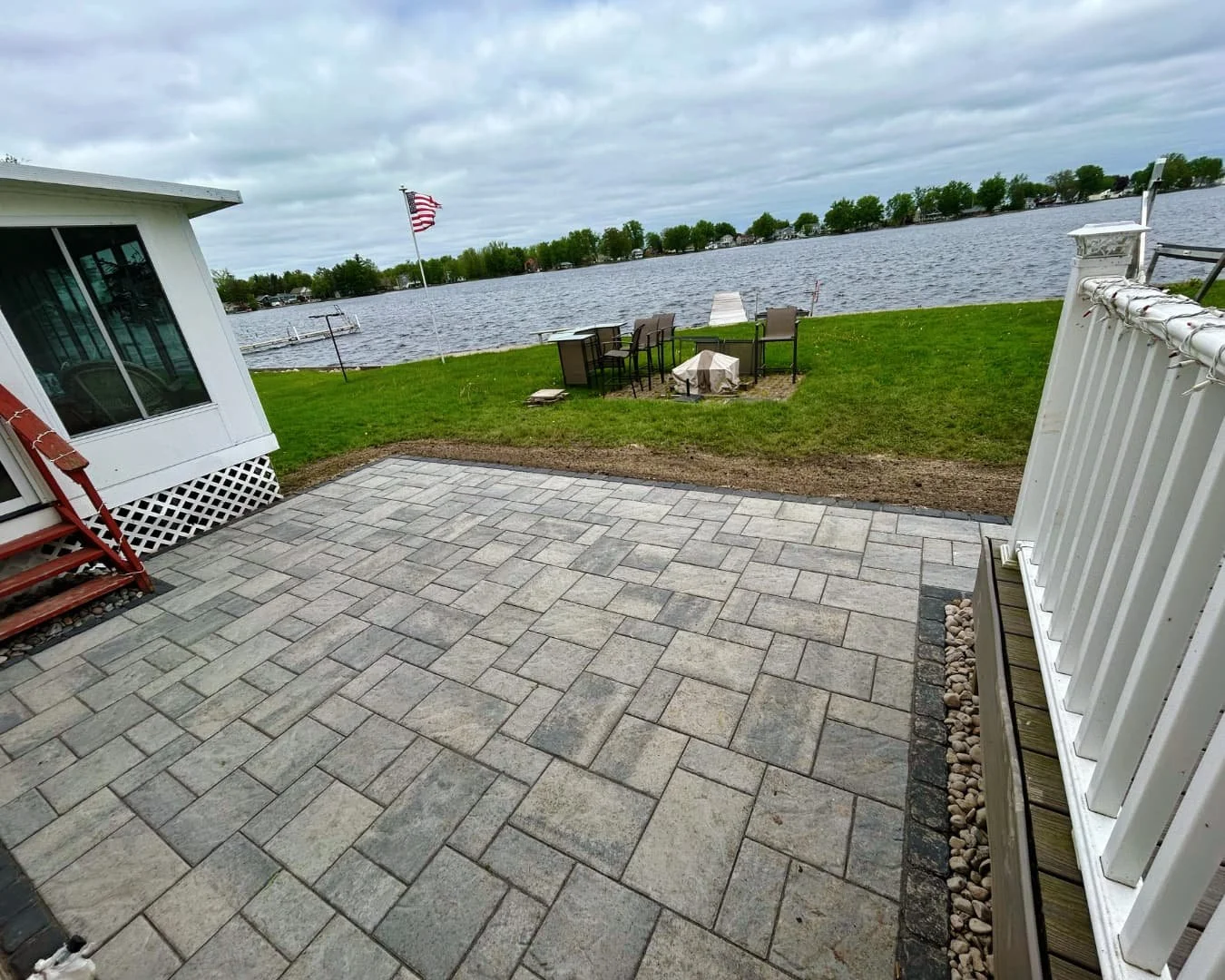 Completed backyard paver patio overlooking the water by Pines and Pavers in Marcellus, New York.