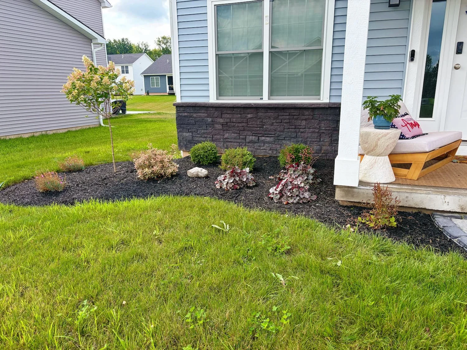 Finished paver walkway curving from the driveway to the front entrance with new landscaping in Central NY.