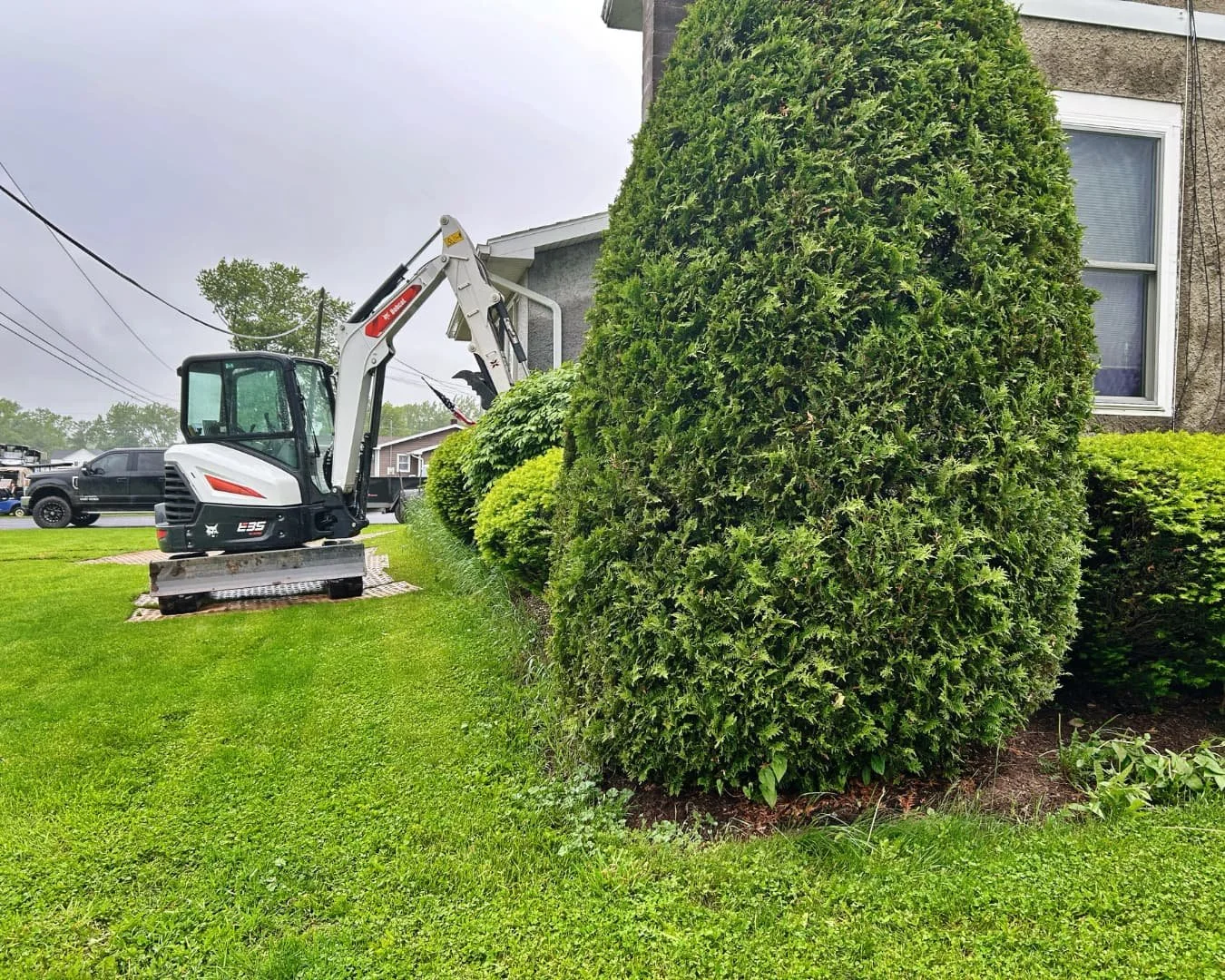 Side yard excavation and plant removal during the project by Pines and Pavers in Fayetteville, New York.