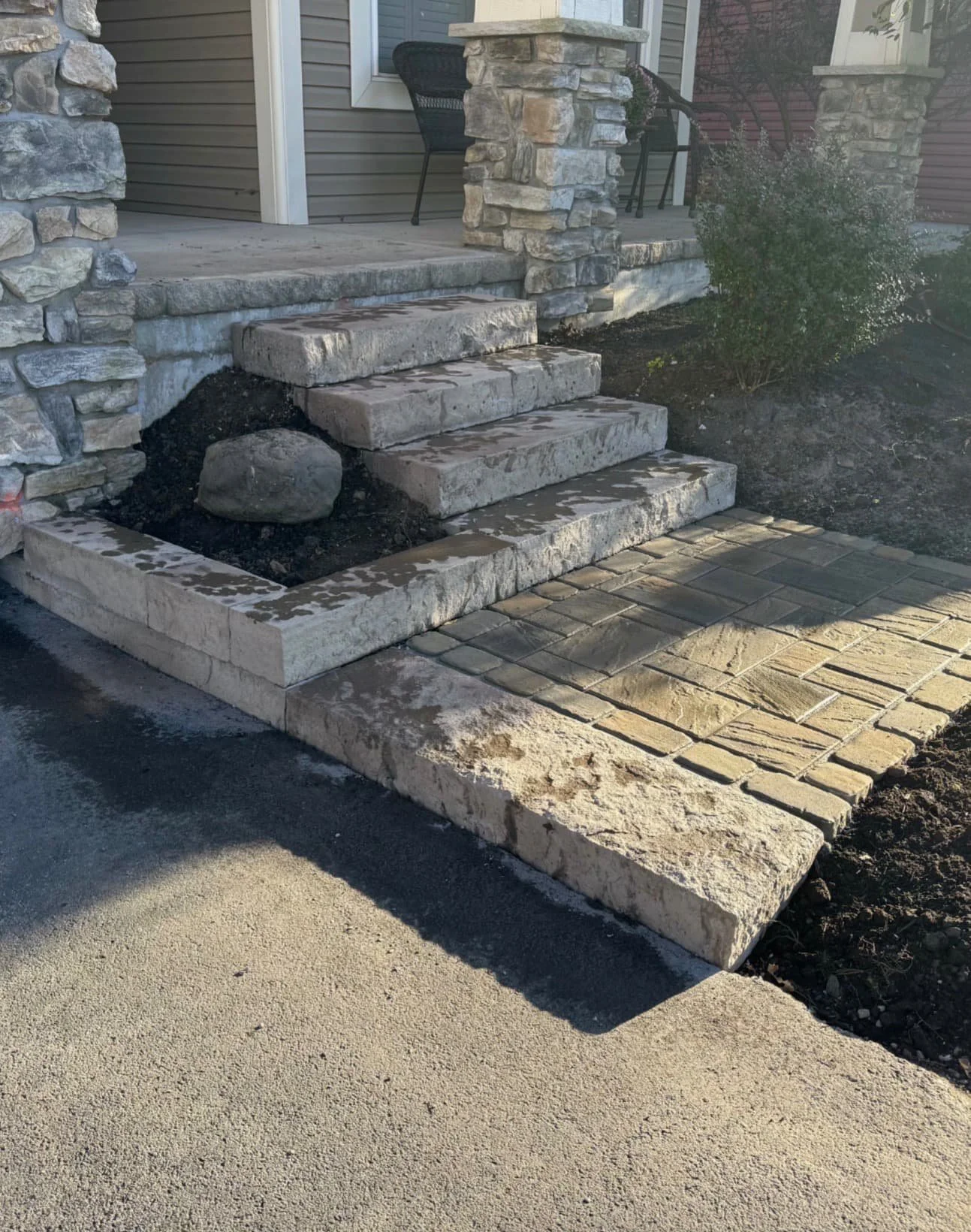 Paver landing and step detail at an Upstate New York home with layered hardscape design and clean edges.