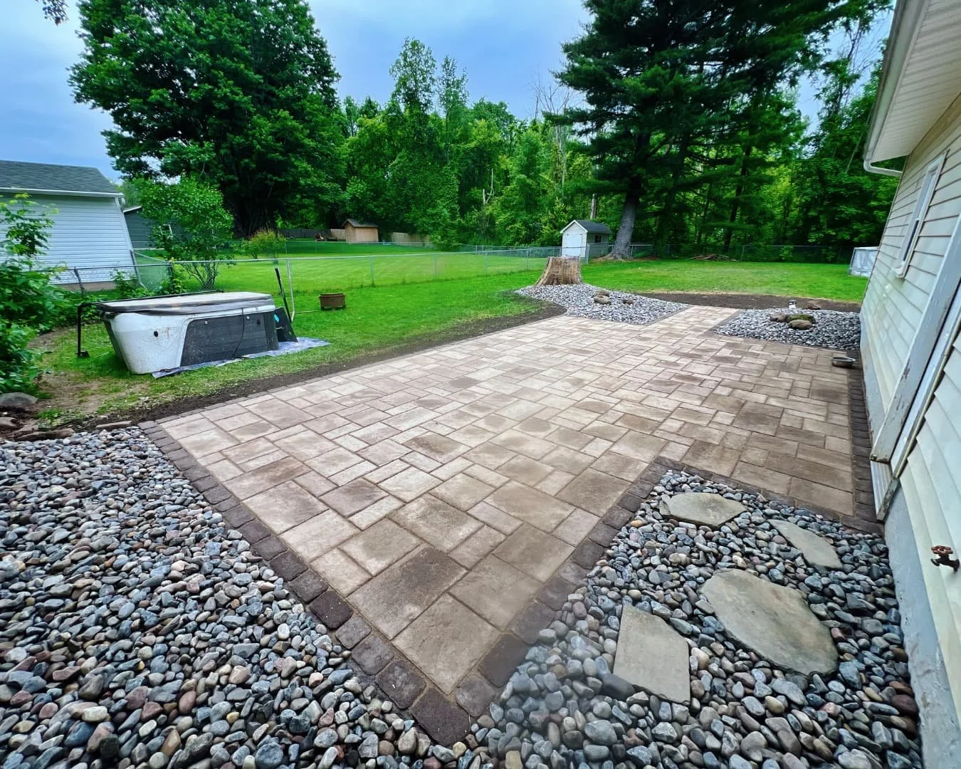Paver patio area beside the home completed by Pines and Pavers in Central New York.