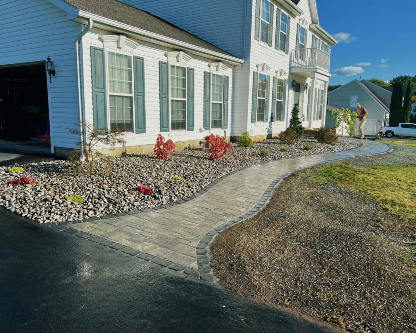 Front patio and entry hardscape at an Upstate New York home with stone accents and a clean finished layout.
