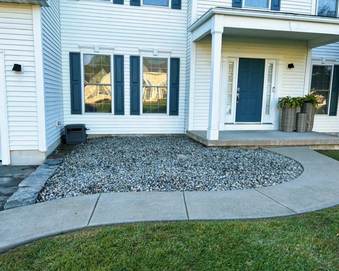 Front yard bed preparation at a Baldwinsville, NY home with newly shaped soil and defined planting space.