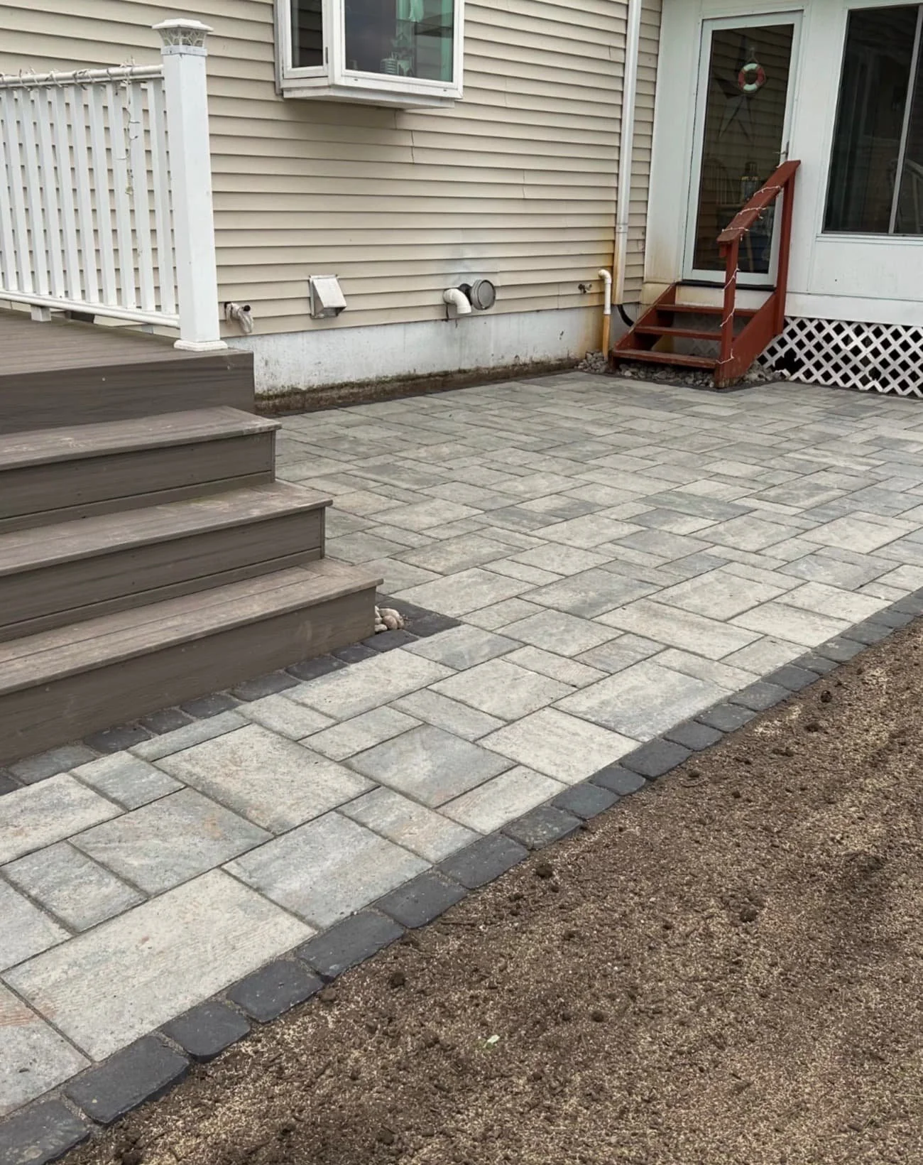Front steps with paver landing at a Baldwinsville, NY home featuring a clean hardscape entry design.