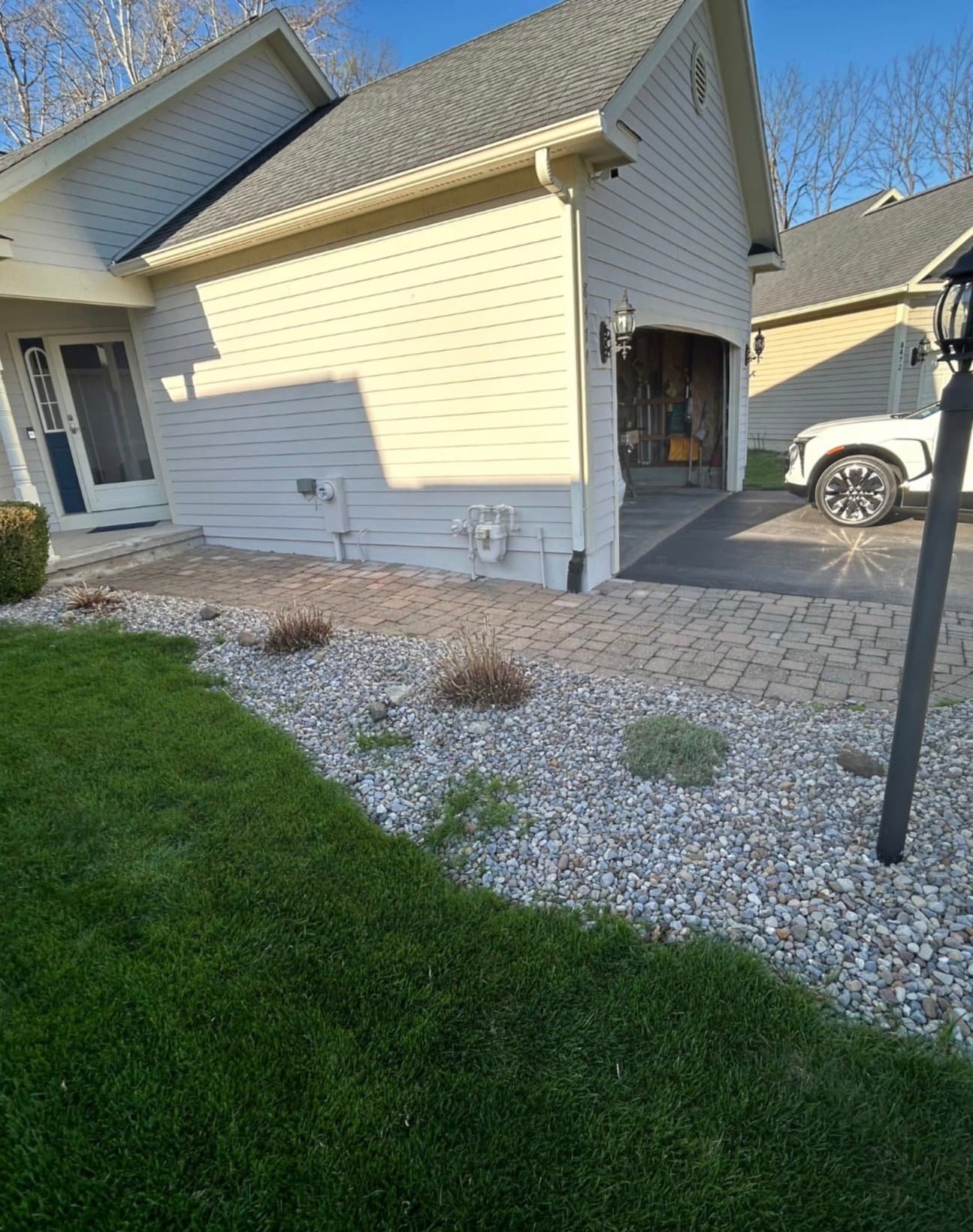 Side yard stone border and fresh landscaping at a Fayetteville, NY home with clean grading and decorative rock.