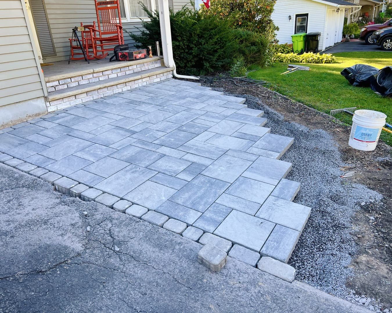 Finished front entry paver patio at a Manlius, NY home with curved border detail and a clean hardscape layout.