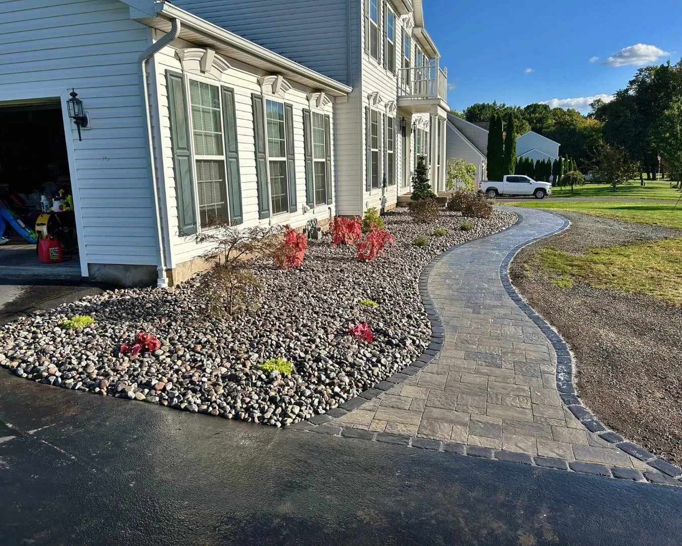 River rock bed and entry walkway detail completed by Pines and Pavers in Baldwinsville, New York.