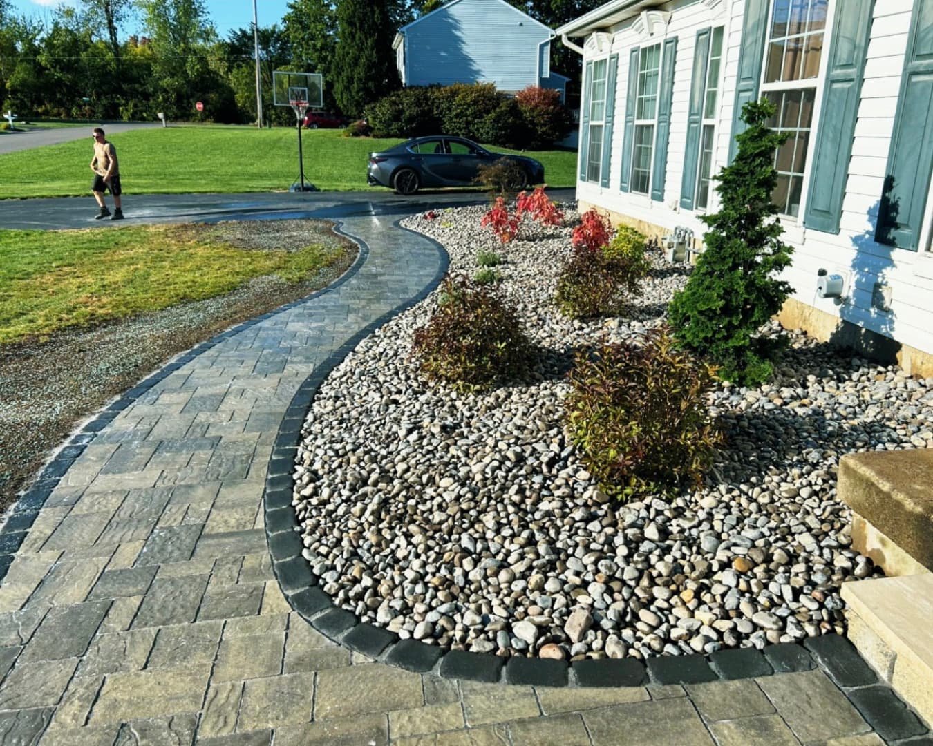 Curved paver entry steps and landing at a Skaneateles, NY home with a clean layered hardscape design.