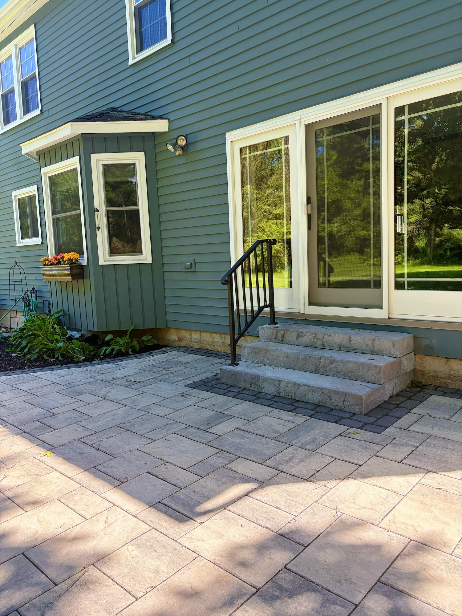 Large custom paver patio designed to create a functional outdoor living and entertaining space in Central New York.