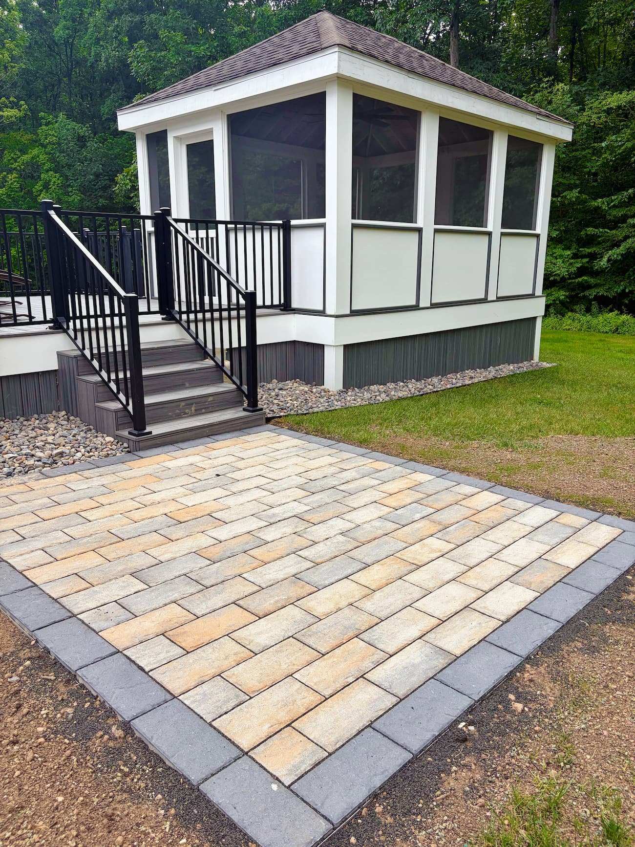 Custom paver walkway with decorative stone border and landscape lighting in Central NY.