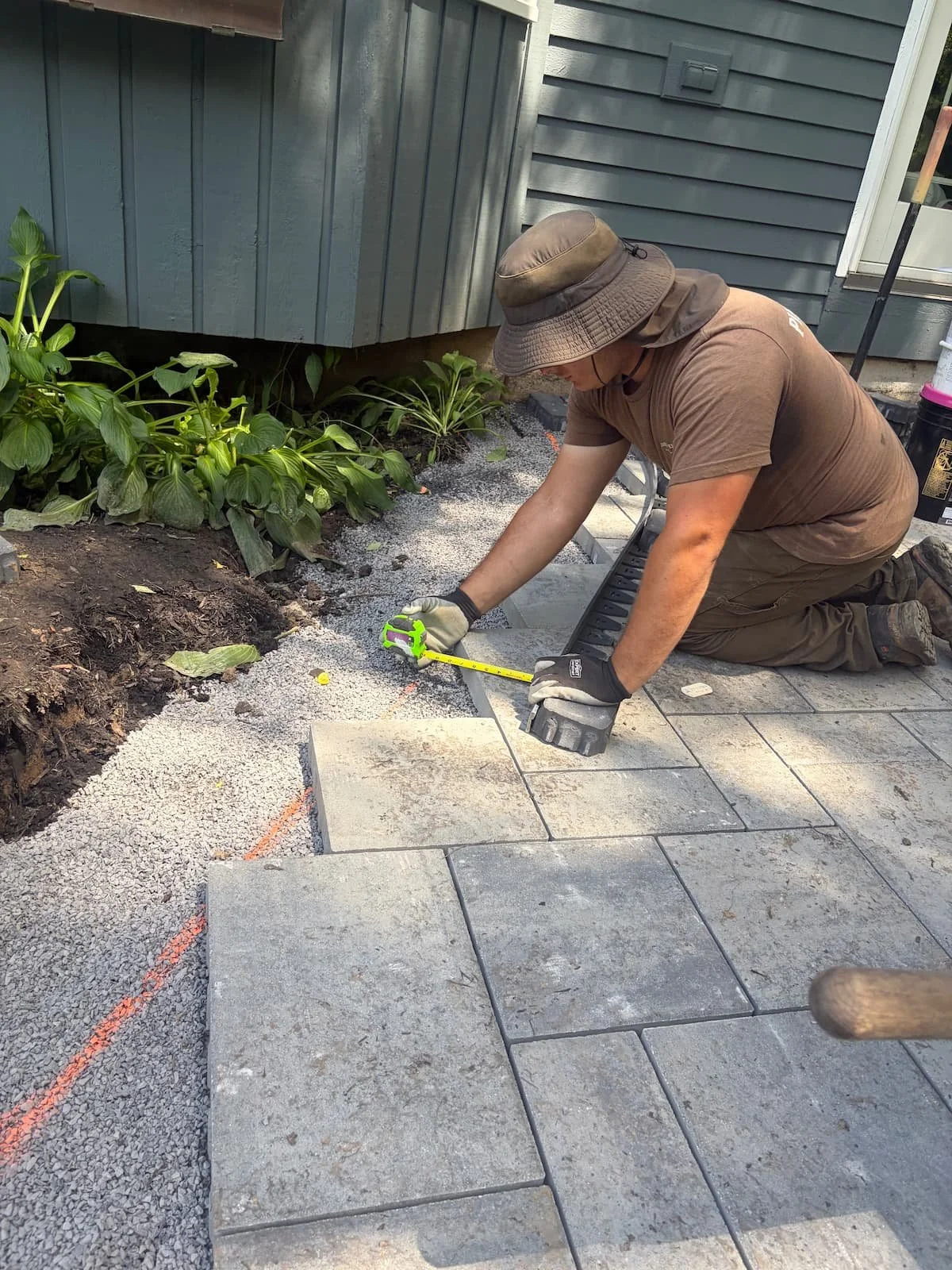 Custom paver patio installation in progress with precision cuts and detailed stonework in Central New York.