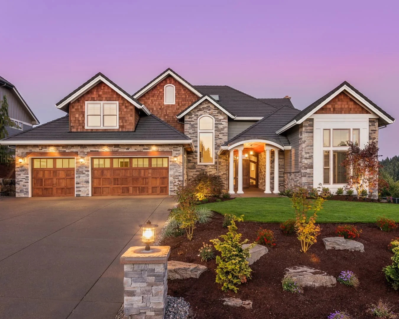 Curb appeal inspiration with evening exterior lighting, fresh mulch beds, and a welcoming front elevation.