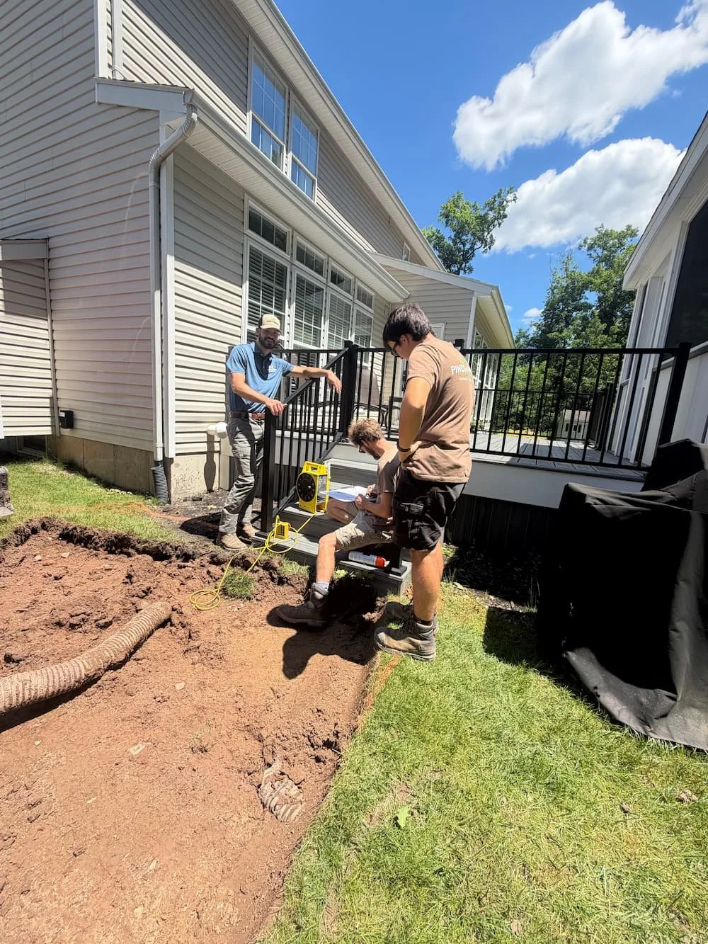 Pines and Pavers crew preparing the ground for a custom paver walkway installation at a Central NY home.