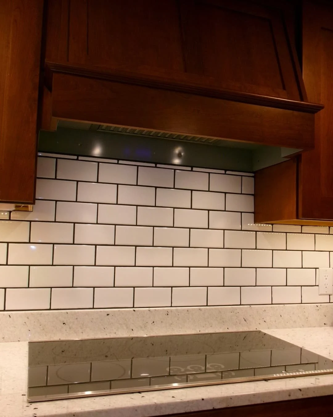 Kitchen counter and backsplash in an Upstate New York renovation with granite surfaces and warm wood cabinets.