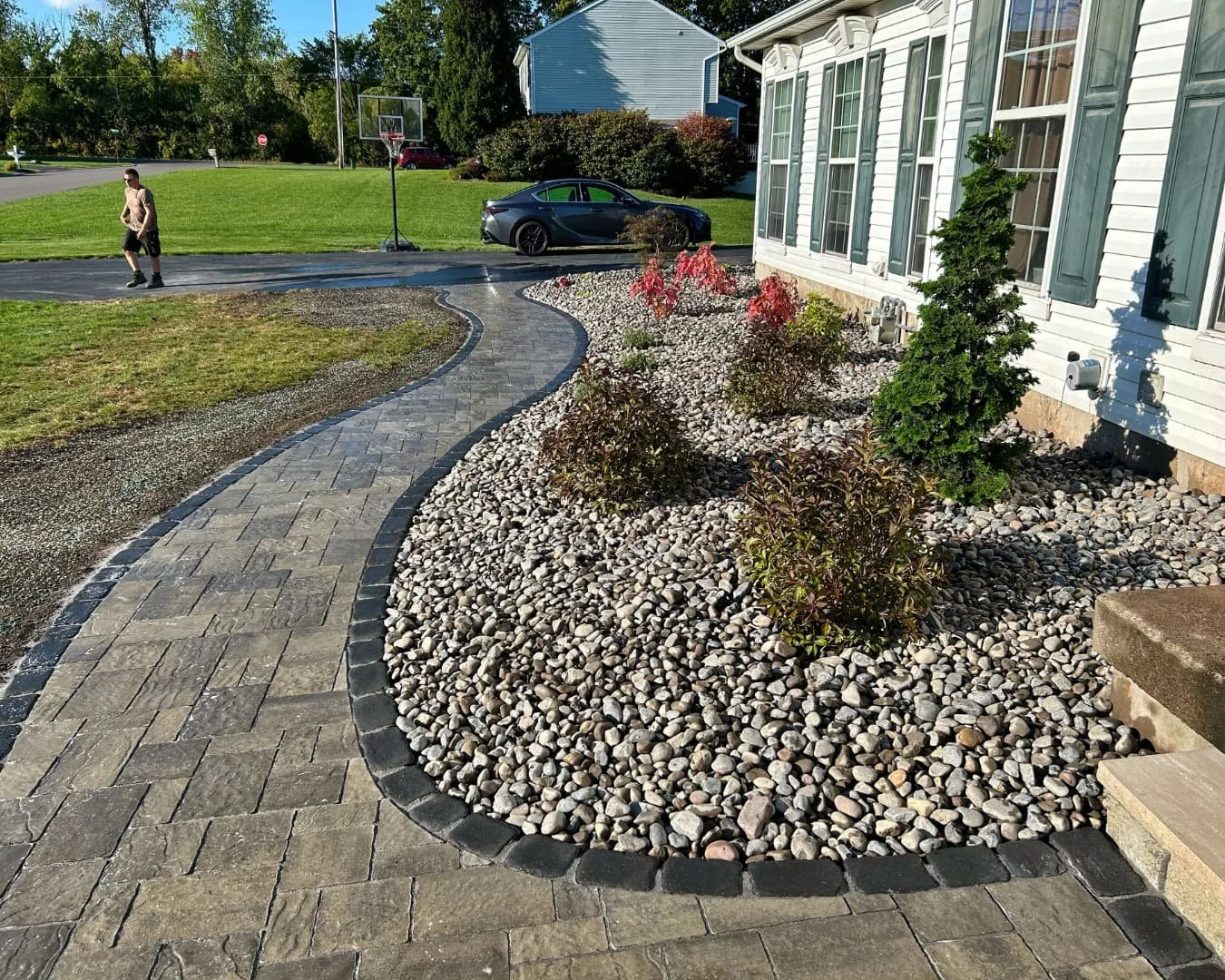 Front yard landscape overview with walkway completed by Pines and Pavers in Baldwinsville, New York.