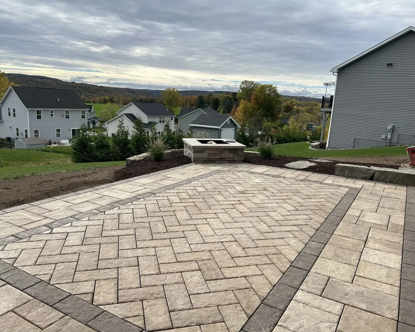 Side yard paver patio and walkway installation at a Baldwinsville, NY home with a clean hardscape layout.