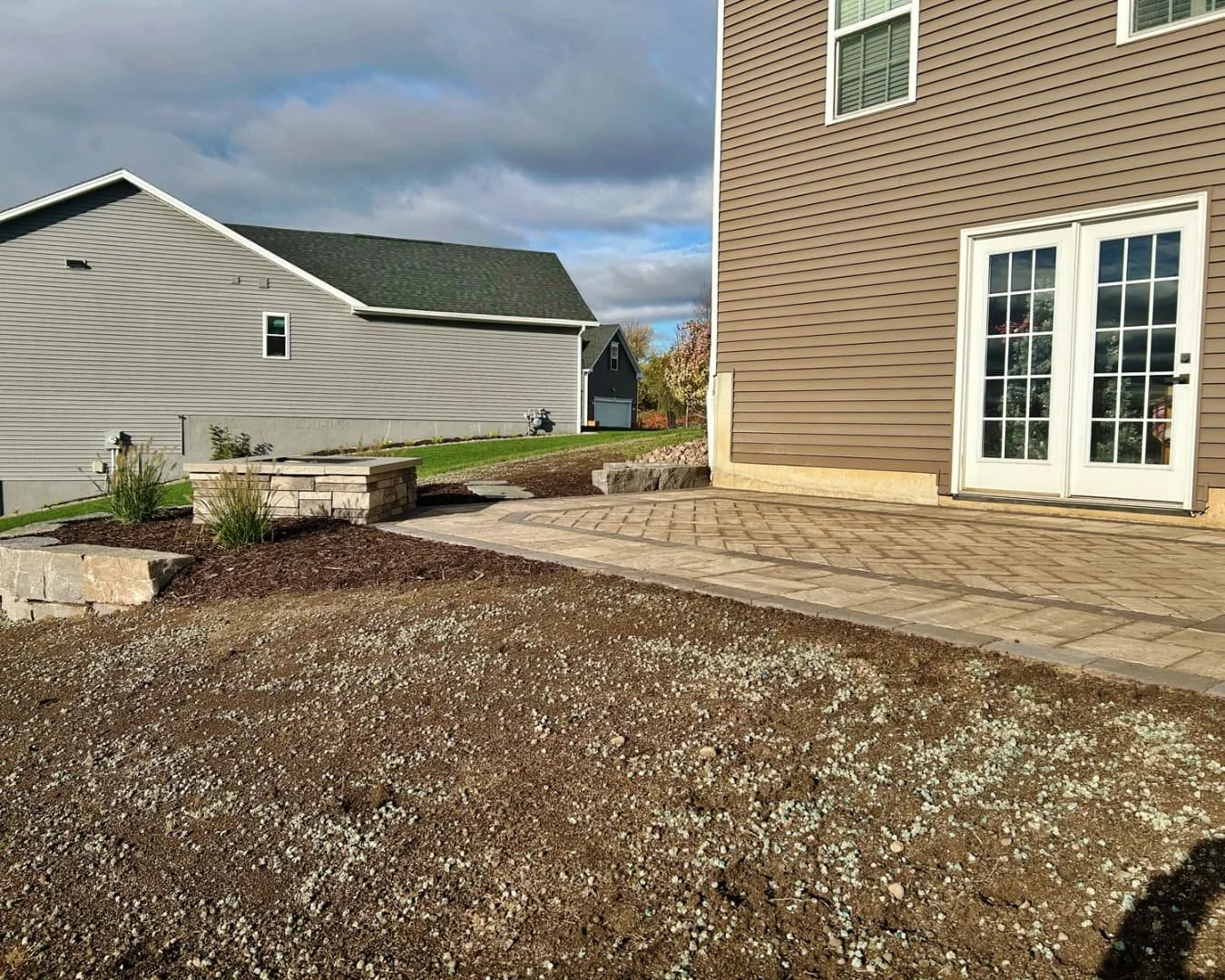Backyard patio with step wall completed by Pines and Pavers in Lysander, New York.