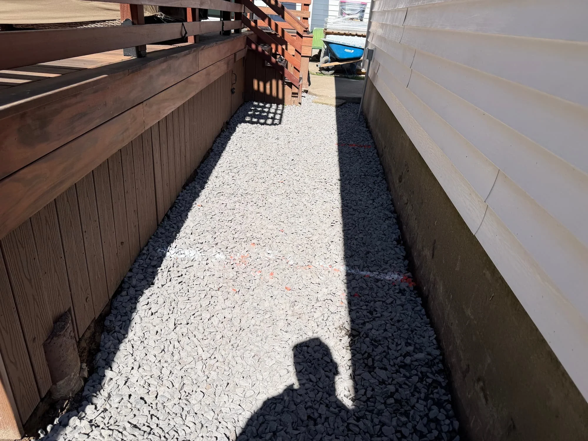 Paver walkway installation progressing alongside a raised wood deck in Central New York.