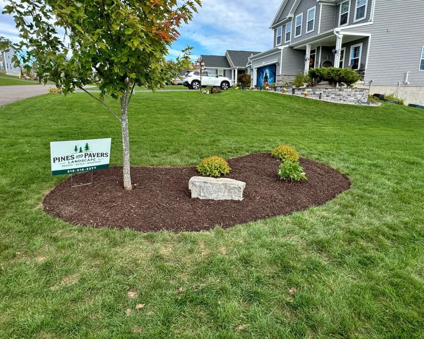 Ornamental tree island bed completed by Pines and Pavers in Lysander, New York.