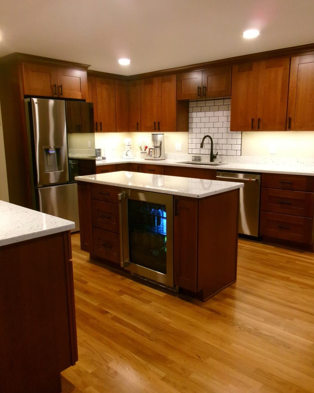 Open kitchen remodel in a Fayetteville, NY home with granite countertops, island seating, and wood cabinetry.