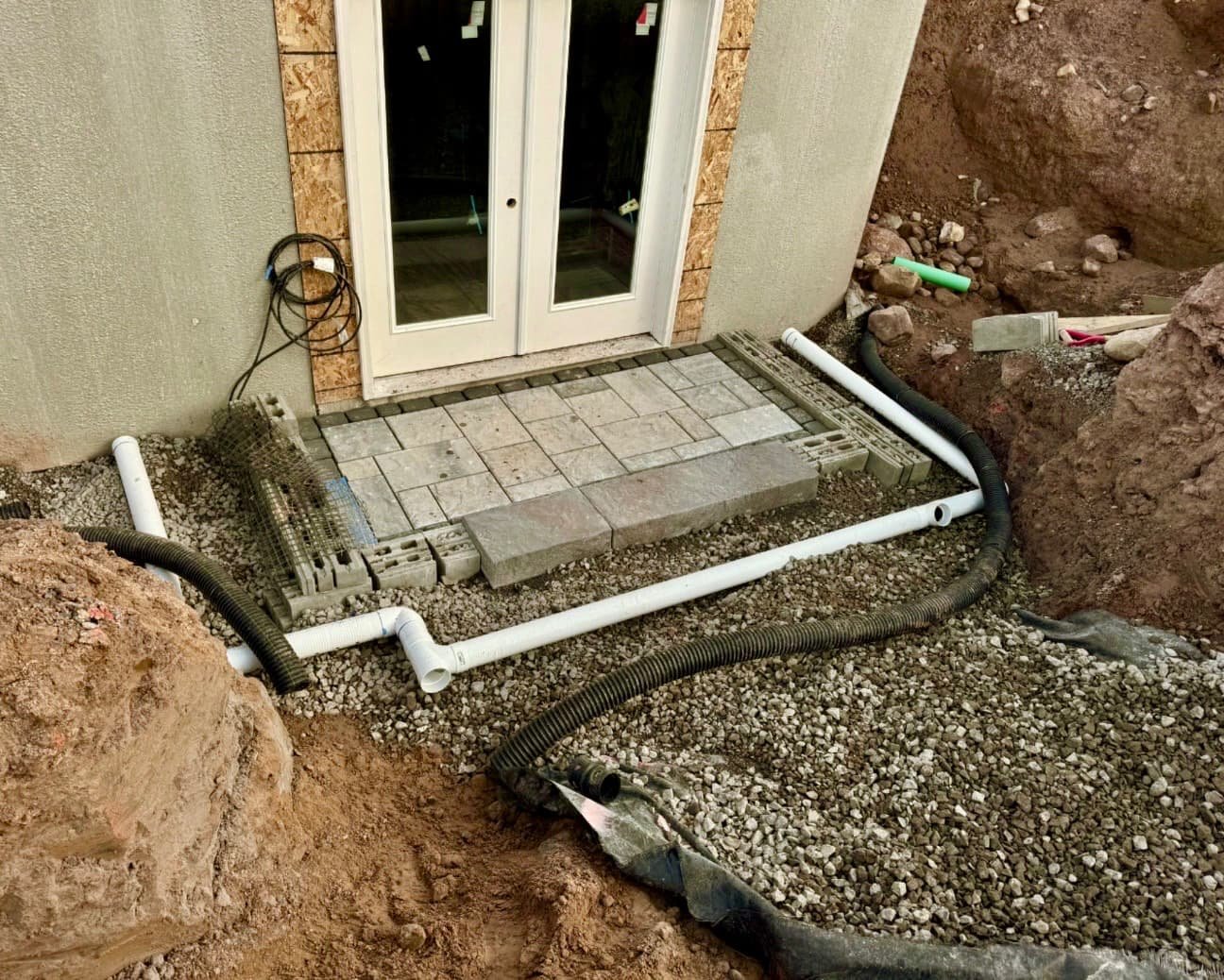 Paver patio and step detail at an Upstate New York home with clean lines and a curved retaining wall edge.