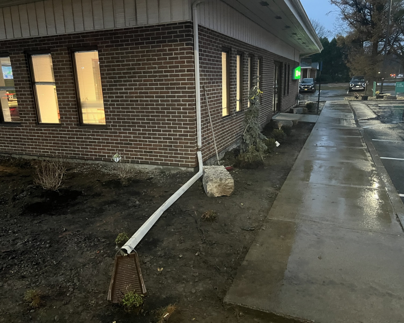 Bank site landscape maintenance at an Upstate New York commercial property with refreshed beds and clean paved access.