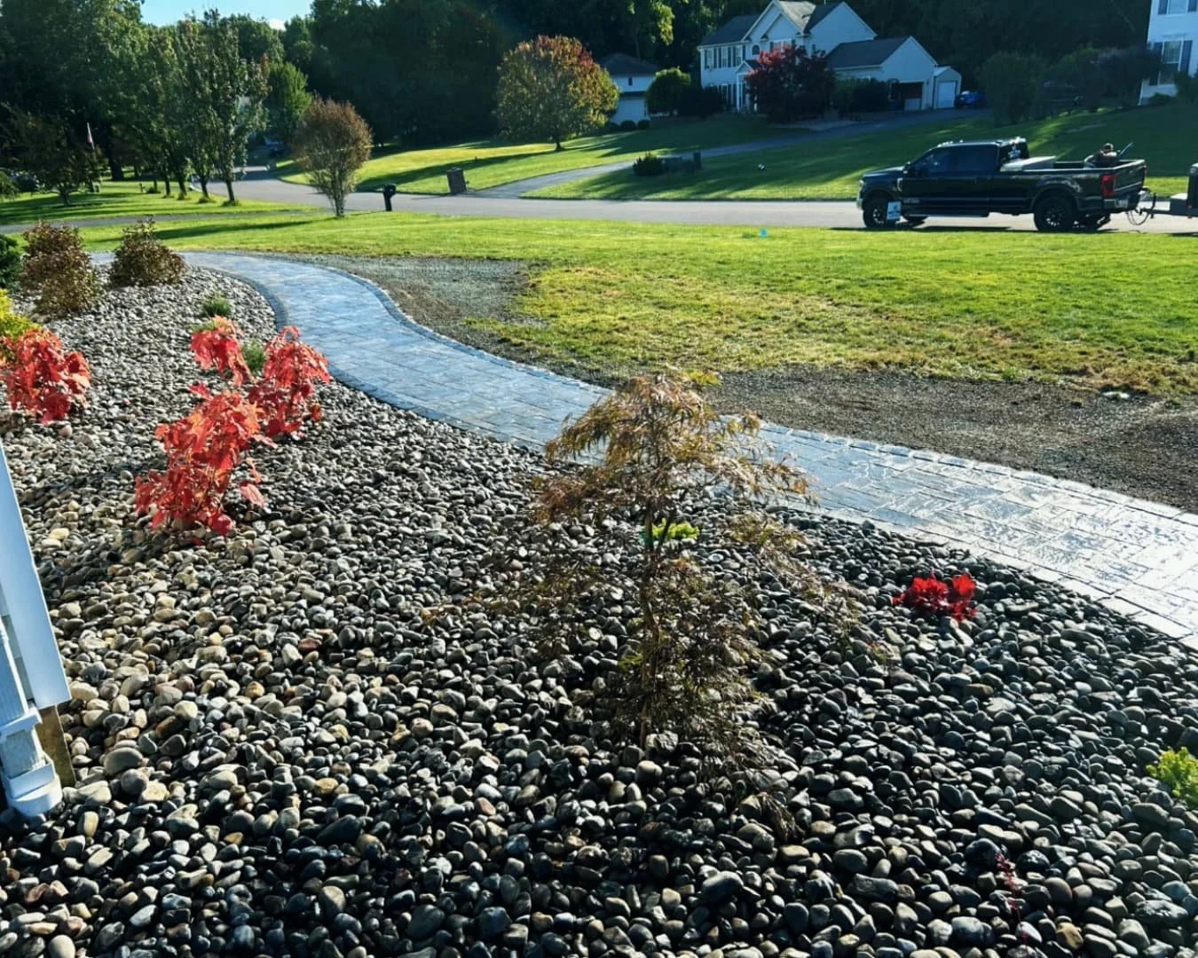 Backyard exterior view of a Central New York home with finished lawn and surrounding hardscape improvements.