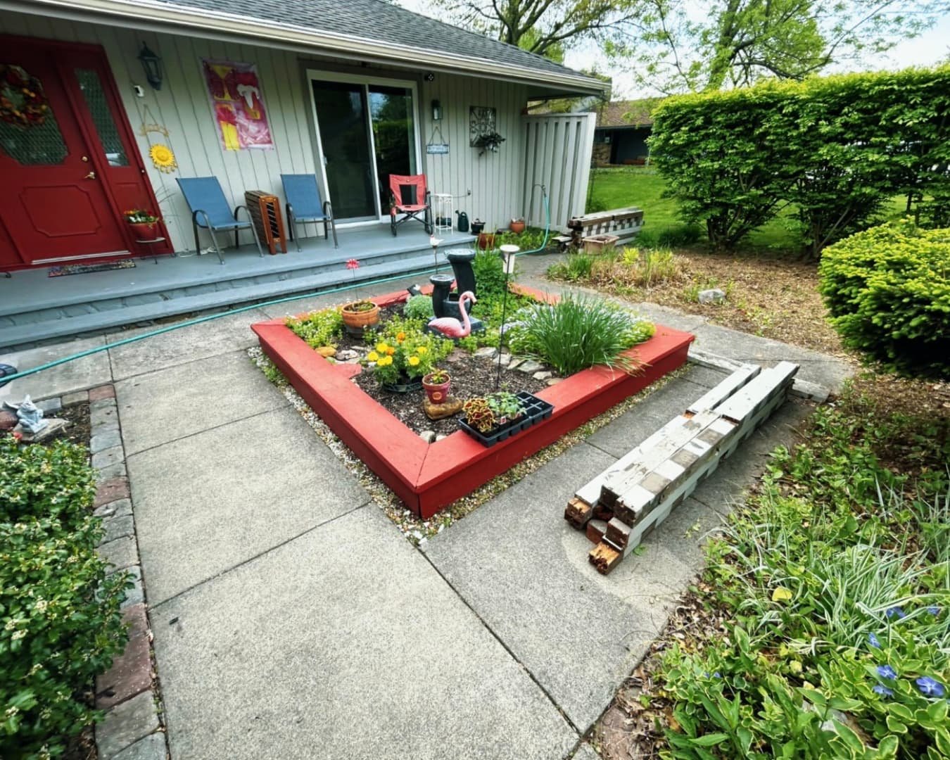 Decorative raised planter feature at an Upstate New York home with colorful flowers and a polished outdoor design.